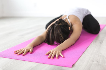 women doing downward dog on pink yoga mat